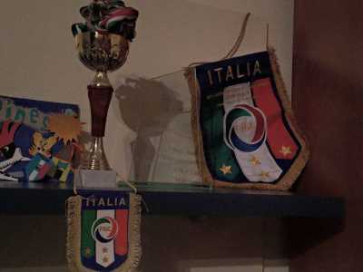 La sua bacheca con i primi trofei: la coppa conquistata con la Virtus di Loseto, il trofeo di vetro in ricordo della partita Italia-Austria e i gagliardetti ricevuti dopo le gare in Nazionale